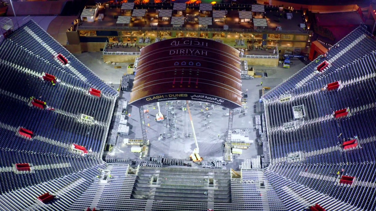 Diriyah Arena from above, with the ring and seating lit at night